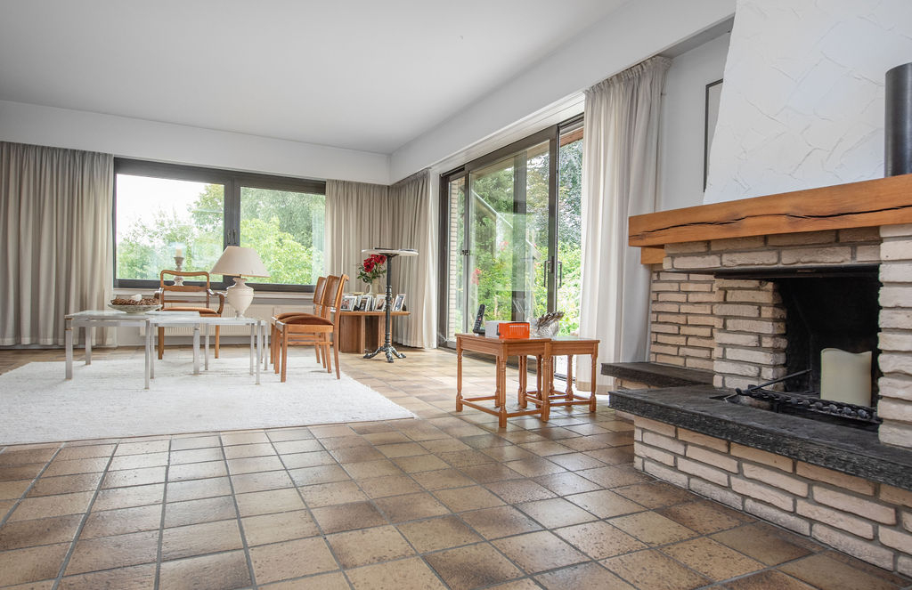 Offener Wohnbereich mit Kamin und Austritt auf die Terrasse